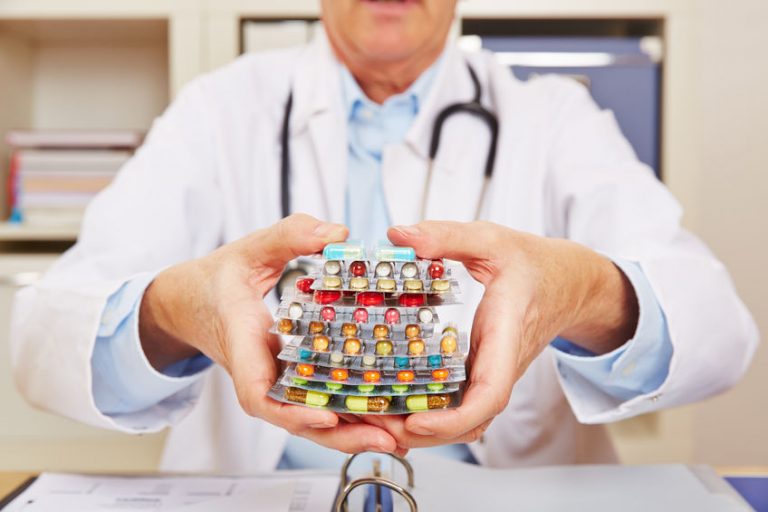 doctor holding many different colorful pills in in hands