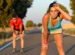 tired fitness couple of runners sweating and taking a rest during marathon training in country road sweaty athletes after running hard